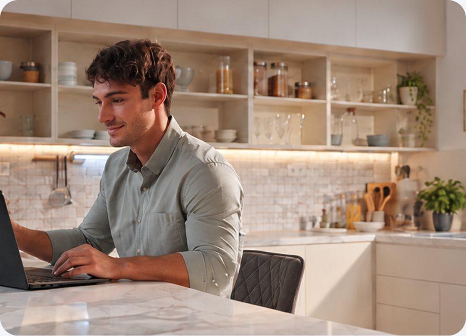 Hombre trabajando en su notebook en la cocina de su casa
