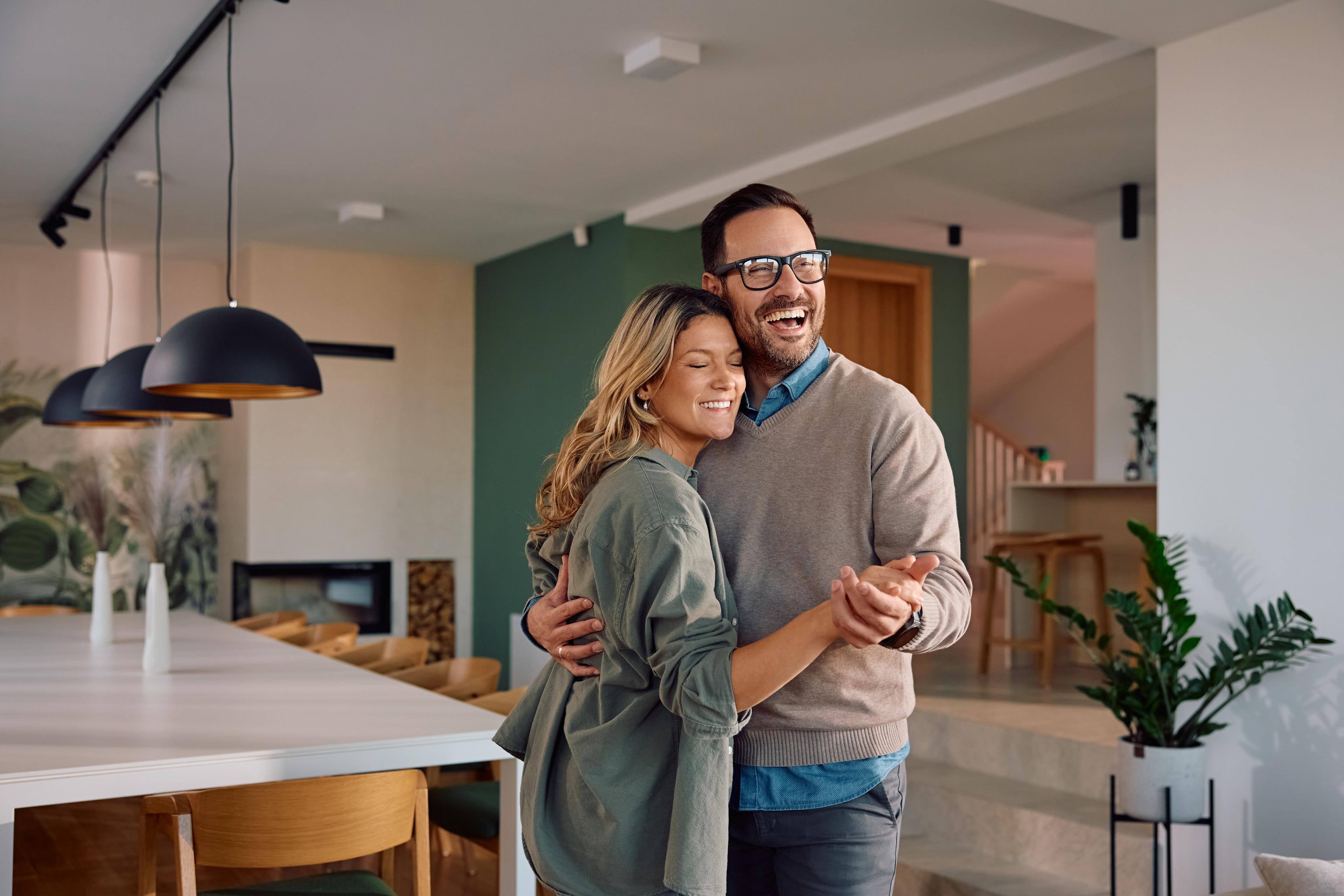 Pareja feliz en el living de su nuevo departamento